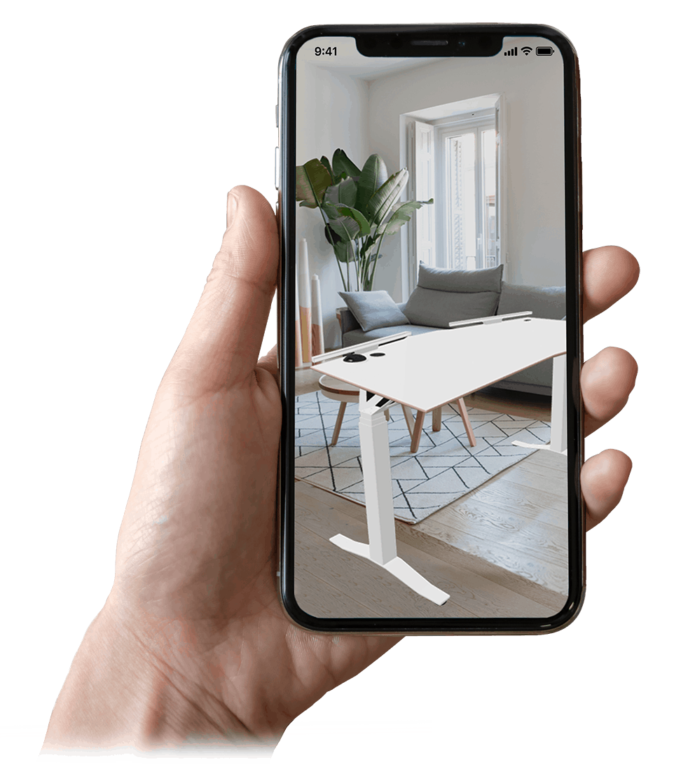 Hand holding phone with an electric height adjustable standing desk viewed in Augmented Reality in office